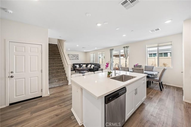 kitchen featuring hardwood / wood-style floors, dishwasher, sink, white cabinets, and a center island with sink