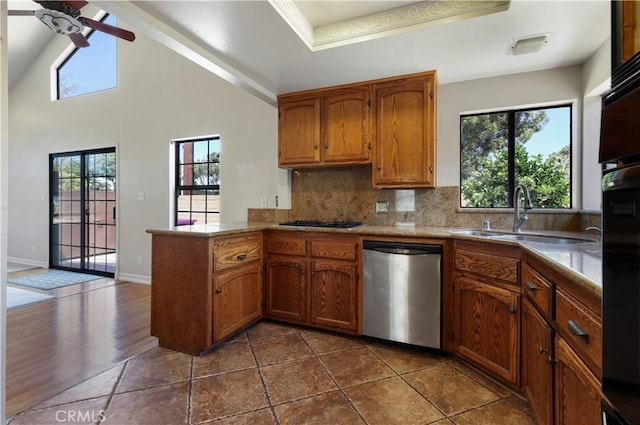 kitchen with sink, dishwasher, ceiling fan, backsplash, and kitchen peninsula