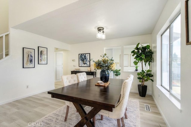 dining area with light hardwood / wood-style flooring and plenty of natural light