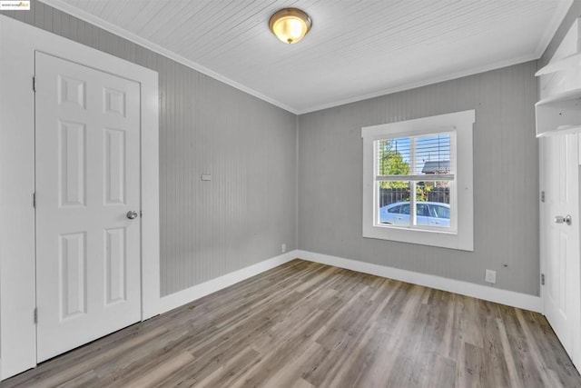 spare room featuring crown molding and light hardwood / wood-style floors