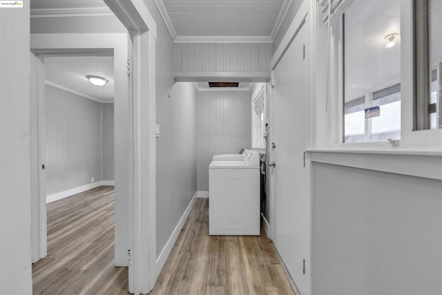 laundry area with light hardwood / wood-style floors, ornamental molding, and washer and dryer