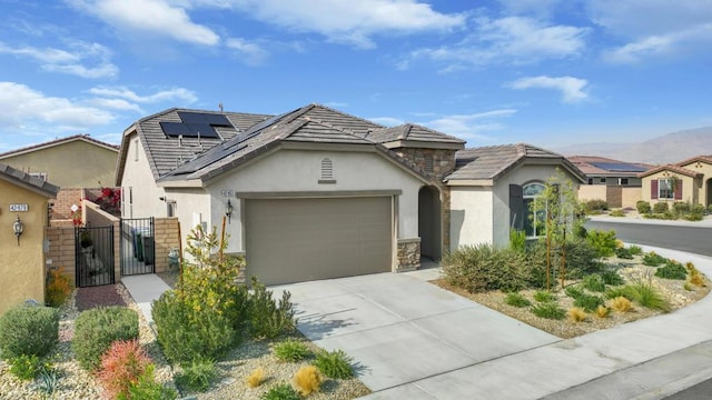 view of front facade with a garage and solar panels