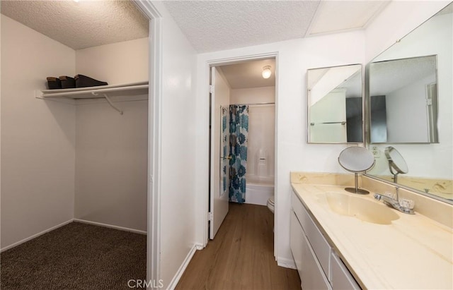 full bathroom featuring toilet, vanity, shower / bathtub combination with curtain, and a textured ceiling