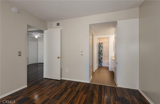 unfurnished bedroom with dark hardwood / wood-style floors and a textured ceiling