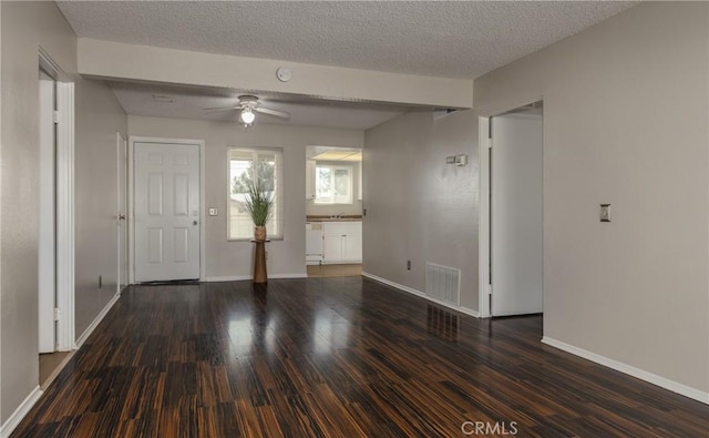 interior space featuring ceiling fan, dark hardwood / wood-style floors, and a textured ceiling