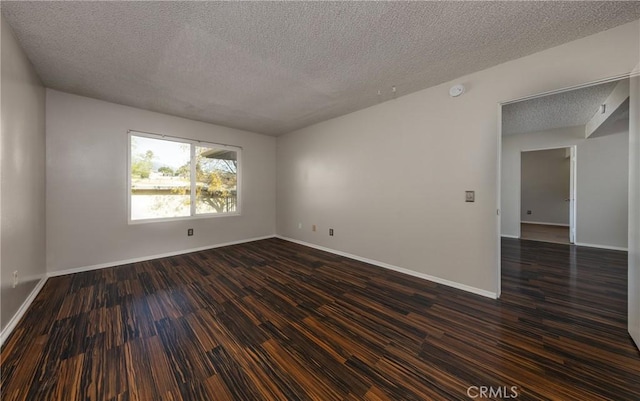 empty room featuring dark wood-type flooring and a textured ceiling