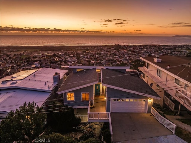 view of front of property with concrete driveway and a water view