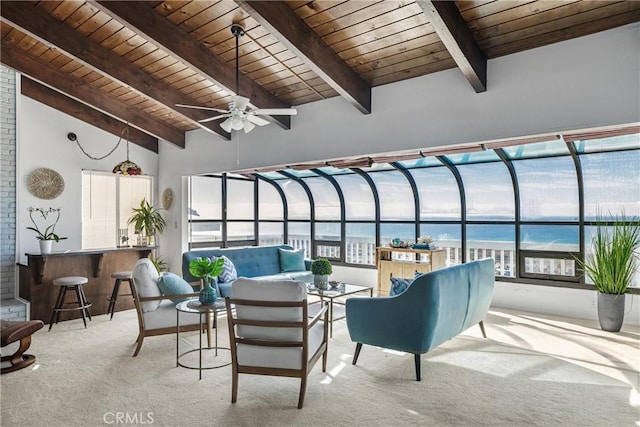 sunroom featuring a water view, ceiling fan, wood ceiling, and lofted ceiling with beams