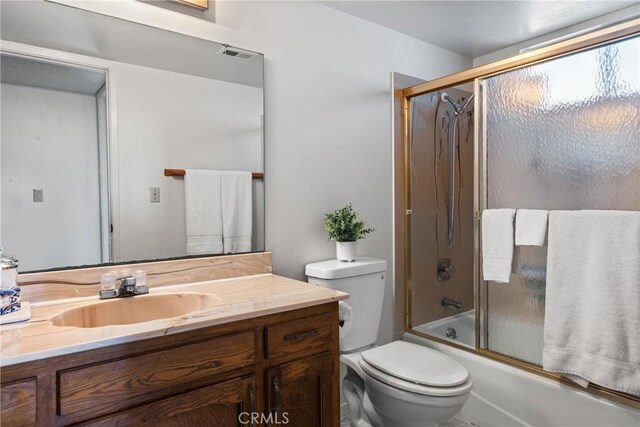 full bathroom featuring vanity, toilet, and combined bath / shower with glass door