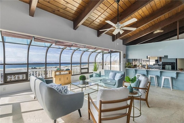 sunroom featuring a water view, lofted ceiling with beams, ceiling fan, a sink, and wooden ceiling