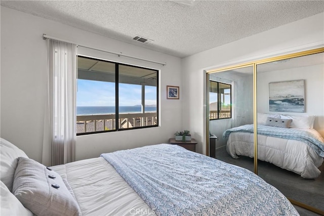 bedroom featuring a textured ceiling, a closet, and visible vents