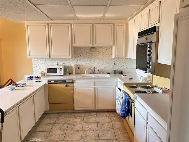 kitchen featuring light tile patterned flooring, white appliances, sink, and a drop ceiling