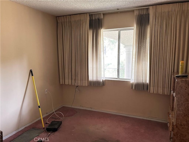 carpeted empty room featuring a textured ceiling