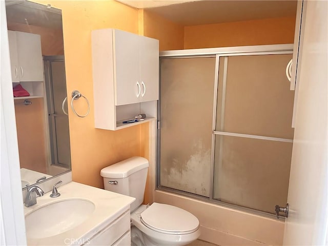 full bathroom featuring vanity, shower / bath combination with glass door, and toilet