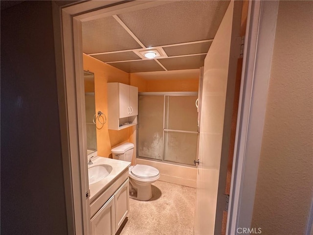 full bathroom with vanity, bath / shower combo with glass door, and toilet