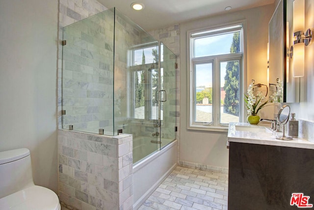 full bathroom featuring vanity, a healthy amount of sunlight, shower / bath combination with glass door, and toilet