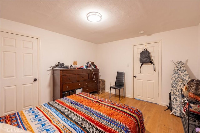 bedroom featuring light hardwood / wood-style floors and a textured ceiling