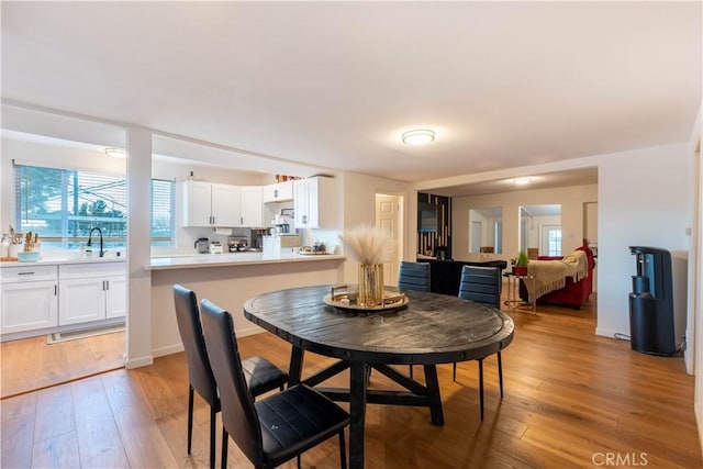 dining room with sink and light wood-type flooring