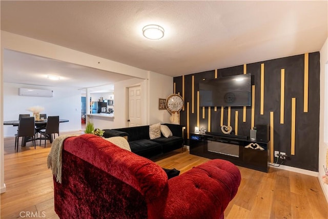 living room featuring an AC wall unit and light wood-type flooring