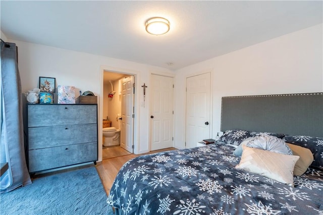 bedroom featuring ensuite bathroom and hardwood / wood-style floors