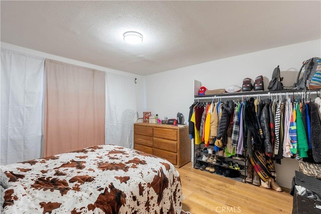 bedroom featuring hardwood / wood-style floors and a textured ceiling