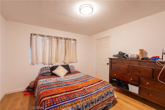 bedroom featuring a textured ceiling and light wood-type flooring