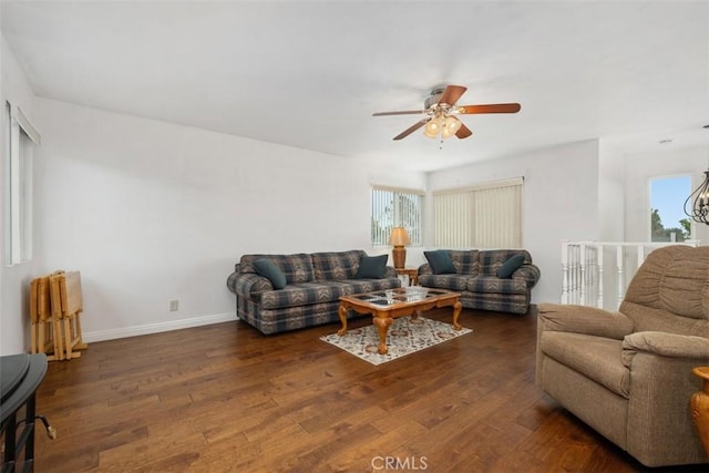 living room featuring dark wood-type flooring and ceiling fan