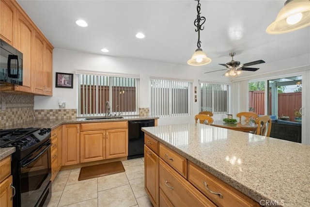 kitchen featuring sink, light stone counters, decorative light fixtures, decorative backsplash, and black appliances