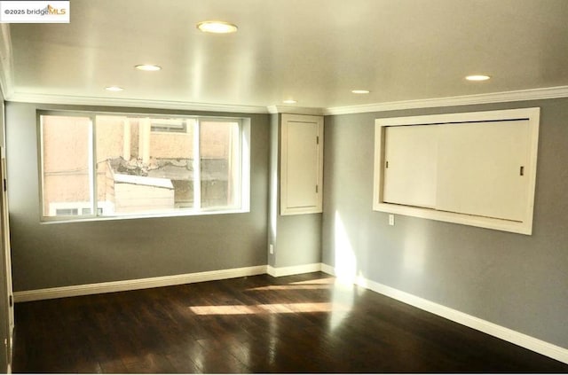 empty room with ornamental molding and dark hardwood / wood-style floors