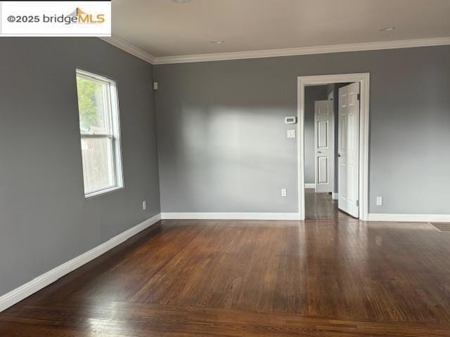 spare room featuring crown molding and dark hardwood / wood-style floors