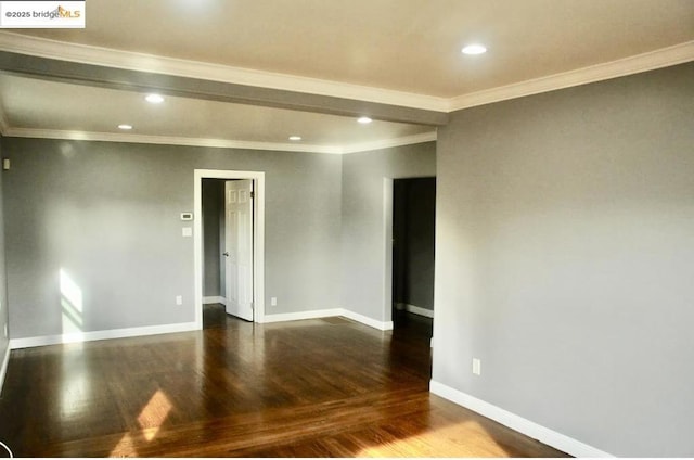 spare room featuring ornamental molding and dark hardwood / wood-style flooring