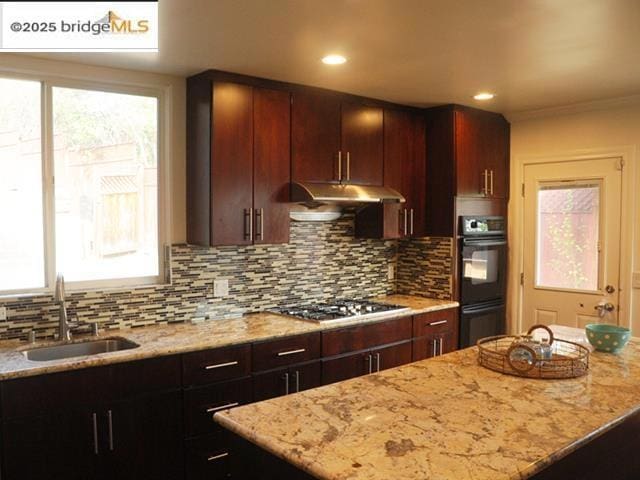 kitchen with stainless steel gas cooktop, sink, tasteful backsplash, double oven, and light stone countertops