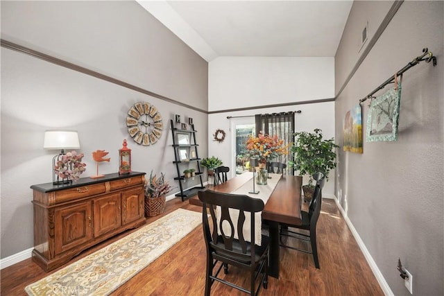 dining space with dark wood-style floors, visible vents, baseboards, and vaulted ceiling