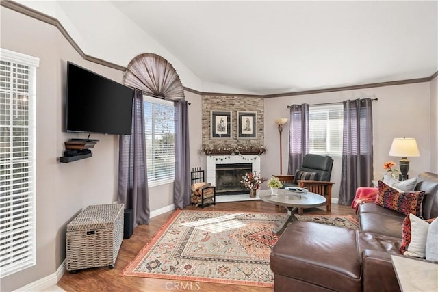 living room with lofted ceiling, a large fireplace, a healthy amount of sunlight, and wood finished floors