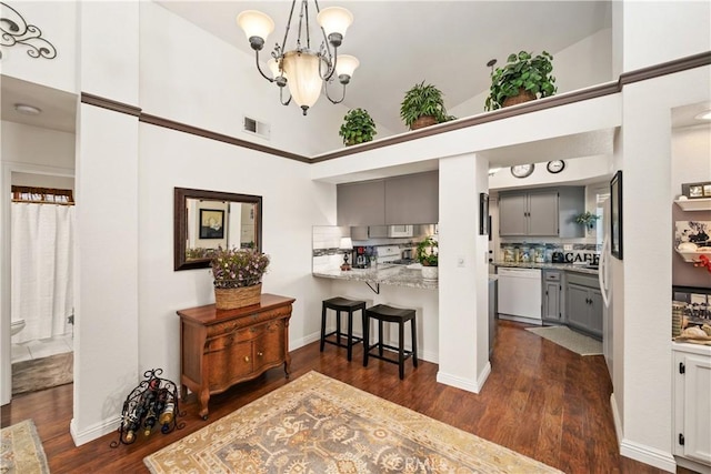 kitchen featuring a chandelier, dark wood-type flooring, visible vents, gray cabinets, and dishwasher