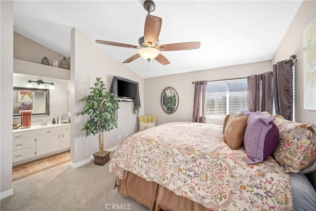 bedroom featuring light carpet, baseboards, lofted ceiling, ensuite bath, and ceiling fan