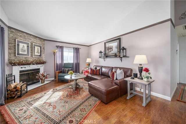 living room featuring a brick fireplace, crown molding, and wood-type flooring