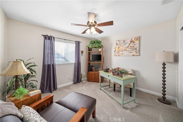 office area with light carpet, a ceiling fan, and baseboards