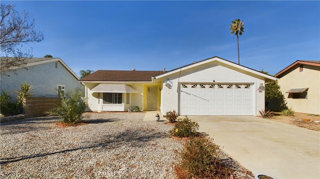 ranch-style house featuring concrete driveway, an attached garage, and stucco siding