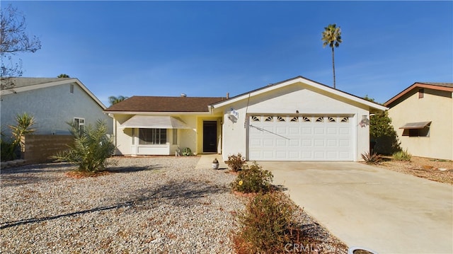 ranch-style house with a garage, concrete driveway, and stucco siding