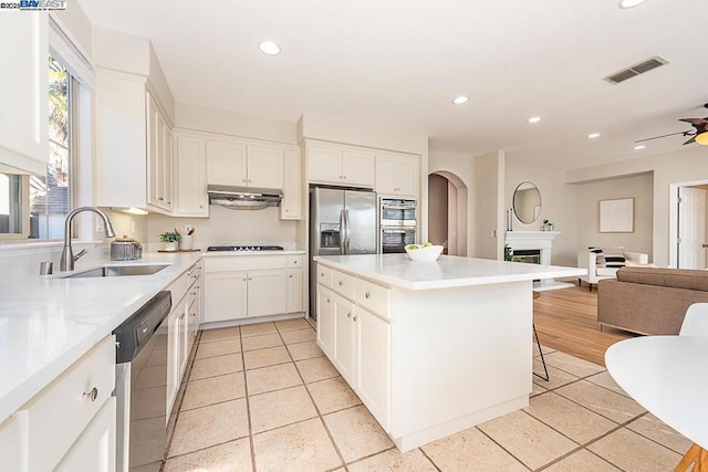 kitchen with sink, stainless steel appliances, a breakfast bar, and white cabinets