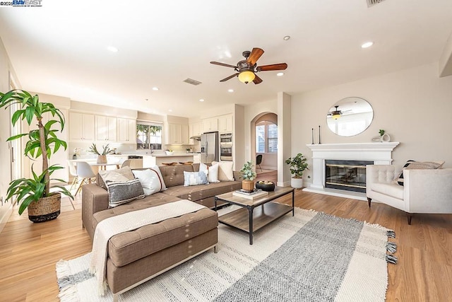 living room featuring ceiling fan and light wood-type flooring