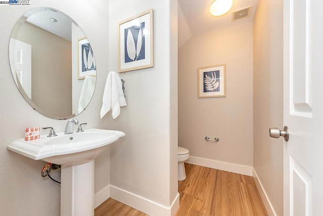 bathroom featuring hardwood / wood-style floors and toilet