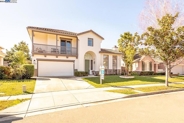 mediterranean / spanish house featuring a garage, a front lawn, and a balcony