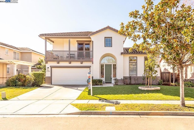 mediterranean / spanish home featuring a garage, a balcony, and a front yard