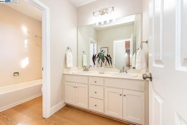 bathroom with vanity, wood-type flooring, and shower / bathing tub combination