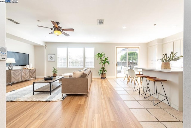 living room with ceiling fan and light wood-type flooring