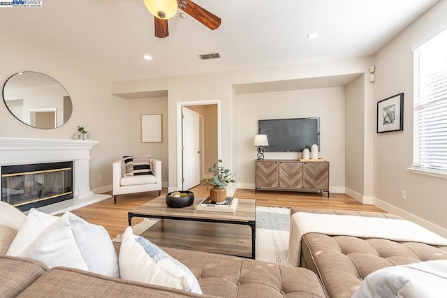 living room with ceiling fan and light hardwood / wood-style flooring