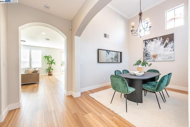 dining room featuring hardwood / wood-style floors, ornamental molding, and a chandelier