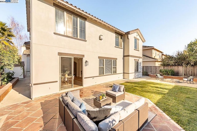 back of property featuring a lawn, a patio area, and an outdoor living space with a fire pit